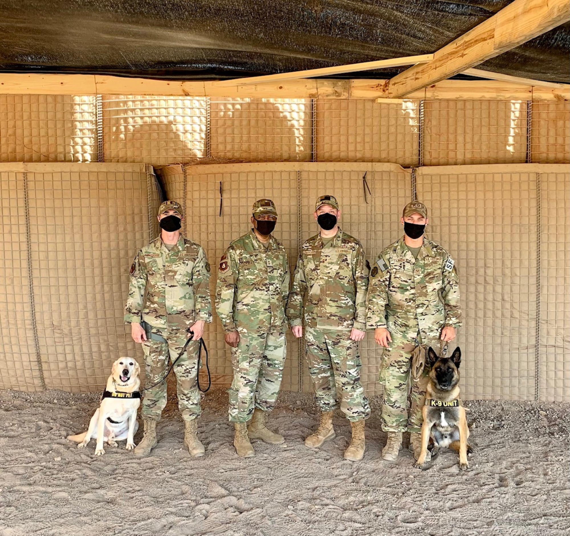U.S. Air Force Staff Sergeants Dakota Farrow and Patrick Saddoris, 726th Expeditionary Air Base squadron military working dog handlers, pose with Maj. Gen. Randall Reed, Third Air Force commander, and Chief Master Sergeant Randy Kwiatkowski, Third Air Force command chief, at Camp Chabelley, Djibouti, April 15, 2021. Third Air Force leadership conducted a visit to the new working dog compound while conducting visits at Camp Lemonnier and Chabelley.  (Courtesy photo by Maj. Tim O’Rouke)
