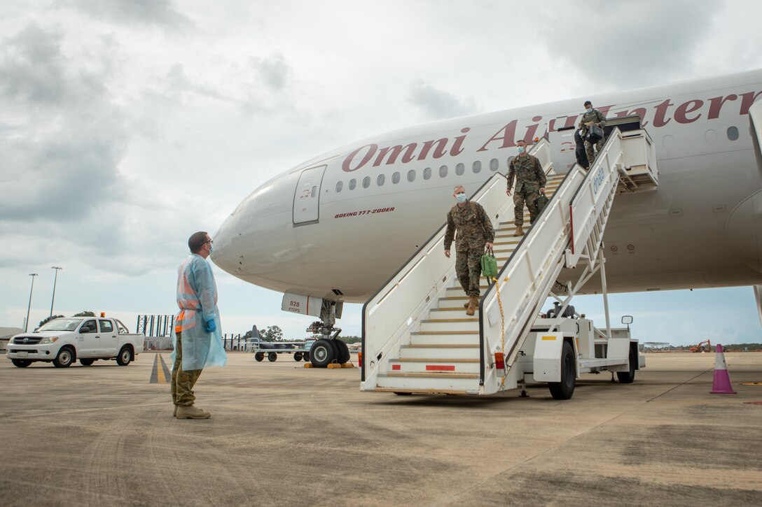 Australian Army Warrant Officer Class 2 Lee Pendlebury, left, an operations warrant officer with Marine Rotational Force – Darwin, prepares to assist U.S. Marines with MRF-D, at Royal Australian Air Force Base, Darwin, NT, Australia, March 22, 2021. Marines and Sailors with MRF-D are required to conduct strict COVID-19 mitigation procedures prior to arrival in Darwin, in compliance with Northern Territory Health Authorities. All service members must provide three documented negative COVID-19 swab tests throughout their travel and prior to being released from a 14-day quarantine period. (U.S. Marine Corps photo by Sgt. Micha Pierce)