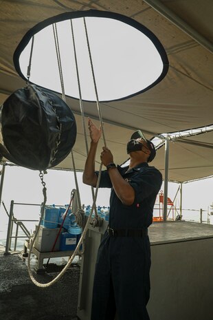 210420-A-IY623-0069 ARABIAN GULF (April 20, 2021) – Quartermaster 3rd Class Delvin Wright, assigned to mine countermeasures ship USS Sentry (MCM 3), raises a day shape used to signal a vessel’s navigational status, during exercise Artemis Trident 21 in the Arabian Gulf, April 20. Artemis Trident 21 is a multilateral mine countermeasures exercise between the UK, Australia, France and U.S., designed to enhance mutual interoperability and capabilities in mine hunting and clearance, maritime security and dive operations, allowing participating naval forces to effectively develop the necessary skills to address threats to regional security, freedom of navigation and the free flow of commerce. (U.S. Army photo by Spc. Evens Milcette Jr.)