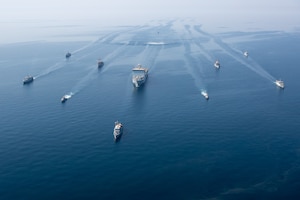 210421-A-BD272-0073 ARABIAN GULF (April 21, 2021) - A multinalional group of mine countermeasure ships from the French Marine Nationale, UK Royal Navy, U.S. Navy and a MH-53E Sea Dragon helicopter, attached to the “Blackhawks” of Helicopter Mine Countermeasures Squadron (HM-15), operate in formation during exercise Artemis Trident 21 in the Arabian Gulf, April 21. Artemis Trident 21 is a multilateral mine countermeasures exercise between the UK, Australia, France and U.S., designed to enhance mutual interoperability and capabilities in mine hunting and clearance, maritime security and dive operations, allowing participating naval forces to effectively develop the necessary skills to address threats to regional security, freedom of navigation and the free flow of commerce. (U.S. Army photo by Spc. Theoren Neal)
