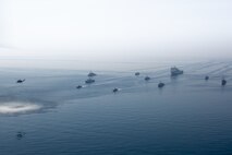 210421-A-BD272-0268 ARABIAN GULF (April 21, 2021) - A multinalional group of mine countermeasure ships from the French Marine Nationale, UK Royal Navy, U.S. Navy and a MH-53E Sea Dragon helicopter, attached to the “Blackhawks” of Helicopter Mine Countermeasures Squadron (HM-15), operate in formation during exercise Artemis Trident 21 in the Arabian Gulf, April 21. Artemis Trident 21 is a multilateral mine countermeasures exercise between the UK, Australia, France and U.S., designed to enhance mutual interoperability and capabilities in mine hunting and clearance, maritime security and dive operations, allowing participating naval forces to effectively develop the necessary skills to address threats to regional security, freedom of navigation and the free flow of commerce. (U.S. Army photo by Spc. Theoren Neal)