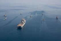 210421-A-BD272-0418 ARABIAN GULF (April 21, 2021) - A multinalional group of mine countermeasure ships from the French Marine Nationale, UK Royal Navy, U.S. Navy and a MH-53E Sea Dragon helicopter, attached to the “Blackhawks” of Helicopter Mine Countermeasures Squadron (HM-15), operate in formation during exercise Artemis Trident 21 in the Arabian Gulf, April 21. Artemis Trident 21 is a multilateral mine countermeasures exercise between the UK, Australia, France and U.S., designed to enhance mutual interoperability and capabilities in mine hunting and clearance, maritime security and dive operations, allowing participating naval forces to effectively develop the necessary skills to address threats to regional security, freedom of navigation and the free flow of commerce. (U.S. Army photo by Spc. Theoren Neal)