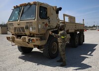 U.S. Army Spc. Marion Regalado, assigned to the 24th Composite Supply Company out of Joint Base Lewis McChord, Washington, directs a medium tactical vehicle driver to a fuel point before departing a staging area during exercise Guardian Response 21 (GR 21) on Camp Atterbury, Indiana, April 27, 2021.