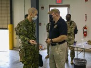 XVIII Airborne Corps Assistant Commanding General, Canadian Brig. Gen. Robert Ritchie, left, talks to Joint Task Force Civil Support Exercise Planner Kevin Woodrum during exercise Guardian Response 21 (GR 21) on Camp Atterbury, Indiana, April 28, 2021.