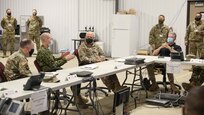 XVIII Airborne Corps Assistant Commanding General, Canadian Brig. Gen. Robert Ritchie, second from left, discusses simulated response operations with Joint Task Force Civil Support Deputy to the Commander Casey Collins, right, during a mission update brief as part of exercise Guardian Response 21 (GR 21) at Muscatatuck Urban Training Center, Indiana, April 28, 2021.