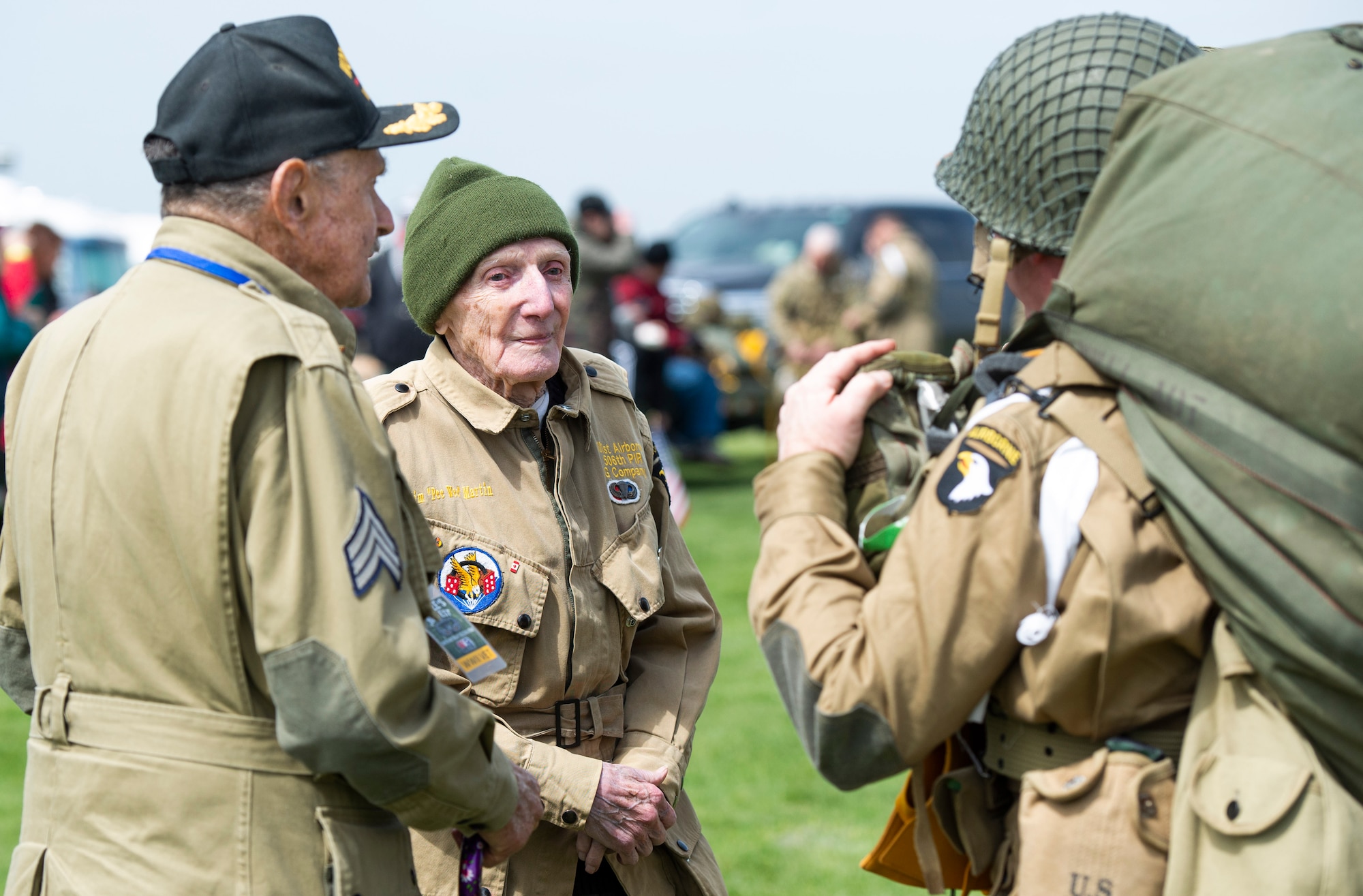 WWII veterans, Dan McBride and Jim “Pee Wee” Martin, greet members of a WWII airborne demonstration team as they leave the drop zone during a 100th birthday celebration held in Martin’s honor, April 23, 2021, in Xenia, Ohio. Both McBride and Martin, served as paratroopers assigned to 101st Airborne Division out of Fort Campbell, Kentucky. (U.S. Air Force photo by Wesley Farnsworth)