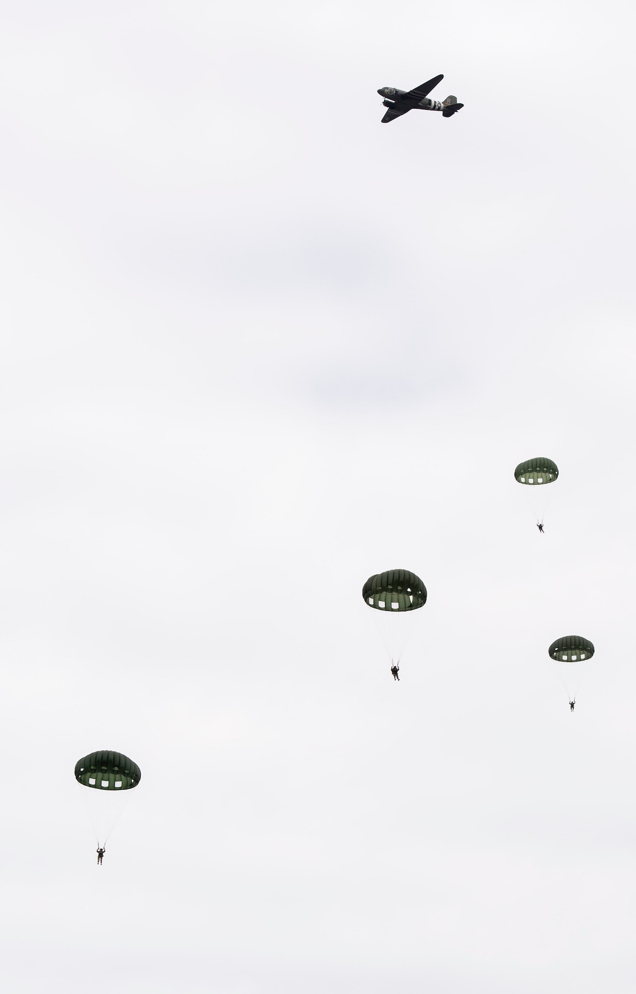 Members of a WWII airborne demonstration team participate in a mass parachute jump during a 100th birthday celebration for WWII veteran Jim “Pee Wee” Martin, April 23, 2021, in Xenia, Ohio. Martin served as a paratrooper assigned to 101st Airborne Division, 506th Infantry Regiment, G Company, out of Fort Campbell, Kentucky. (U.S. Air Force photo by Wesley Farnsworth)