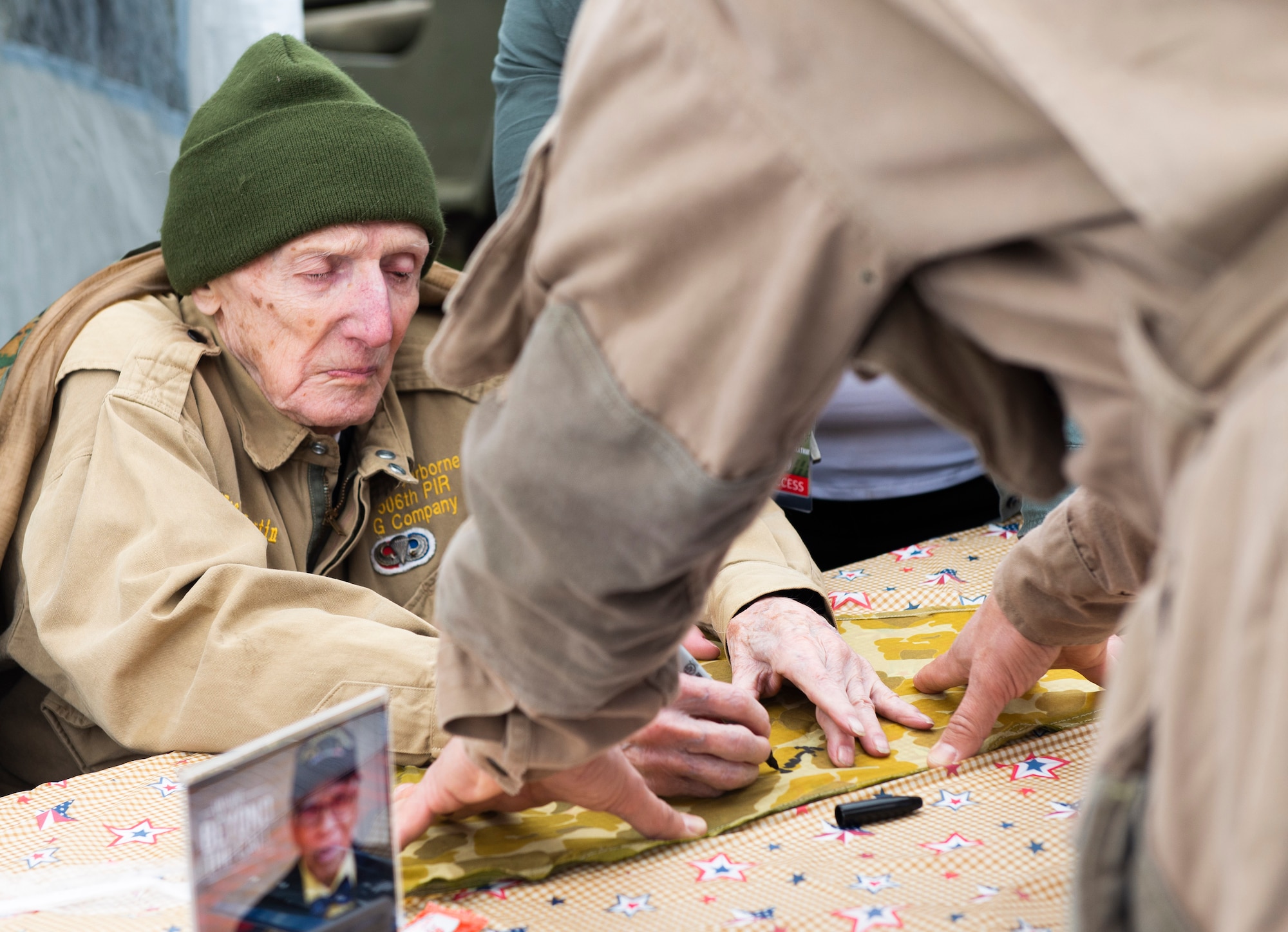 WWII veteran Jim “Pee Wee” Martin signs autographs during a 100th birthday celebration held in his honor, April 23, 2021, in Xenia, Ohio. Martin served as a paratrooper assigned to 101st Airborne Division, 506th Infantry Regiment, G Company, out of Fort Campbell, Kentucky. (U.S. Air Force photo by Wesley Farnsworth)