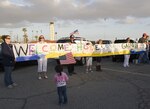 Family members of the Maritime Safety and Security Team (MSST) Los Angeles-Long Beach 91103 hold 'welcome home' signs as they wait to embrace their loved ones as they return from a six-month deployment May 22, 2010. . The unit was deployed to provide maritime force protection to the Joint Task Force aboard the Naval Station Guantanamo Bay. U.S. Coast Guard photo.