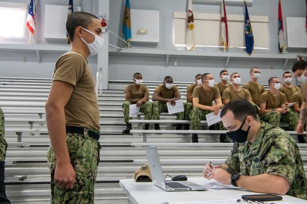 Recruits wait to receive a voluntary COVID 19 vaccination in Pacific Fleet Drill Hall at Recruit Training Command (RTC).