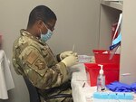 Oklahoma National Guard Airman 1st Class Jaquee Dixon, medical technician, 138th Fighter Wing, prepares COVID-19 vaccines at a community vaccination clinic in Tulsa April 21, 2021. The clinic runs from April 21 to June 15.