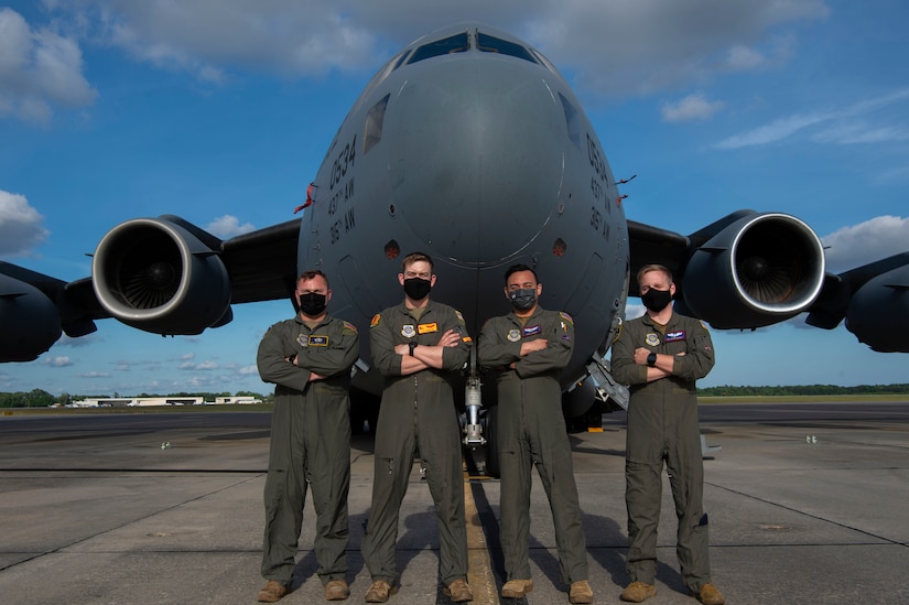 U.S. Air Force Airmen from the 437th Airlift Squadron, pose in front of a C-17 Globemaster III, at Joint Base Charleston, S.C., April 27, 2021.