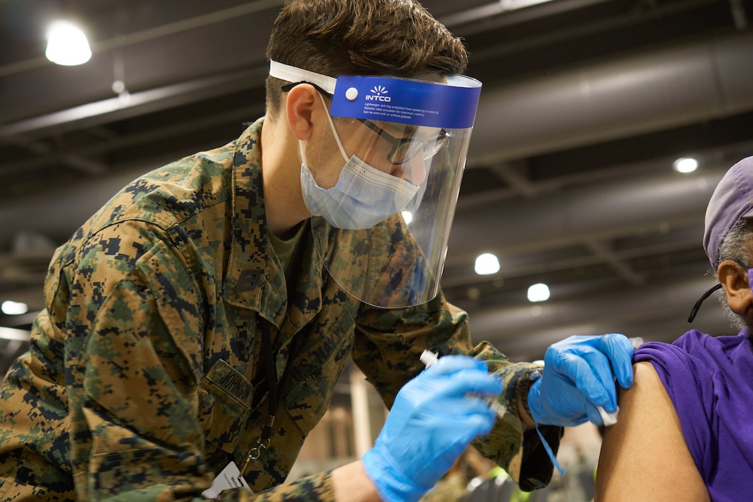 U.S. Navy Hospitalman Josiah Johnson, a native of Erie, Pennsylvania and hospital corpsman with Combat Logistics Battalion 22, administers a vaccination to a local community member at the state-run, federally-supported Community Vaccination Center at the Pennsylvania Convention Center in Philadelphia, April 26, 2021. U.S. Marines and U.S. Navy Sailors with CLB-22, from Camp Lejeune, North Carolina, are deployed in support of the federal vaccine response. U.S. Northern Command, through U.S. Army North, remains committed to providing continued, flexible Department of Defense support to the Federal Emergency Management Agency as part of the whole-of-government response to COVID-19.