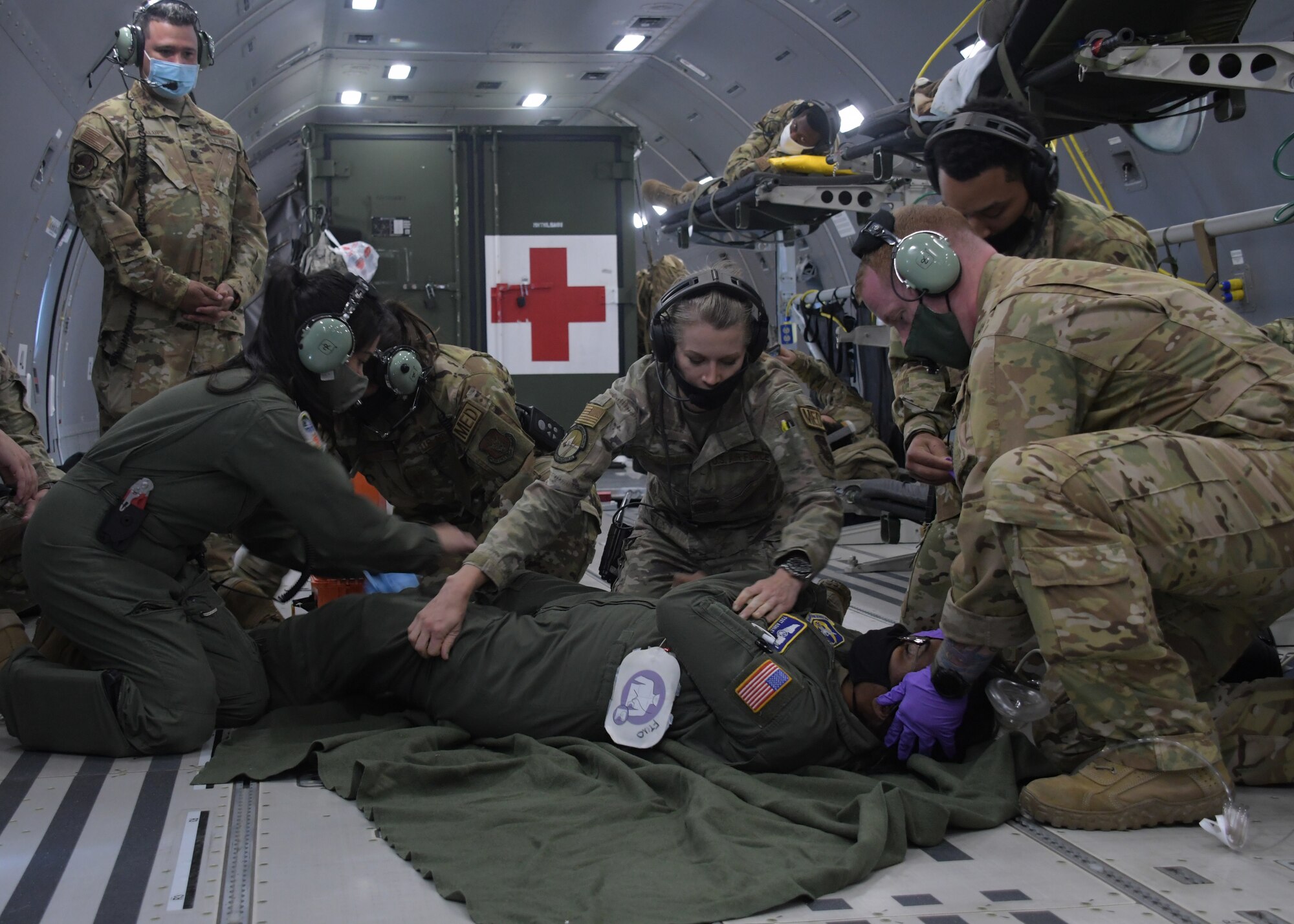Aeromedical evacuation Airmen perform treat a patient during an in-air medical emergency exercise aboard a new KC-46A Pegasus, April 23, 2021. The tanker, from the 916th Air Refueling Wing, was flown by the 77th Air Refueling Squadron, and was used by the aeromedical Airmen to become more familiar with the aircraft and its aeromedical evacuation capabilities. (U.S. Air Force photo by Tech. Sgt. Miles Wilson)