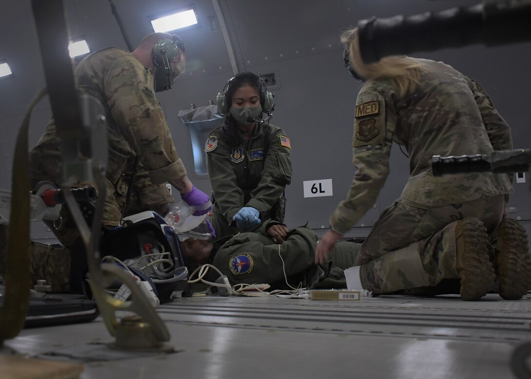 Aeromedical evacuation Airmen perform simulated CPR on a patient during an in-air medical emergency exercise aboard a new KC-46A Pegasus, April 23, 2021. The tanker, from the 916th Air Refueling Wing, was flown by the 77th Air Refueling Squadron, and was used by the aeromedical Airmen to become more familiar with the aircraft and its aeromedical evacuation capabilities. (U.S. Air Force photo by Tech. Sgt. Miles Wilson)