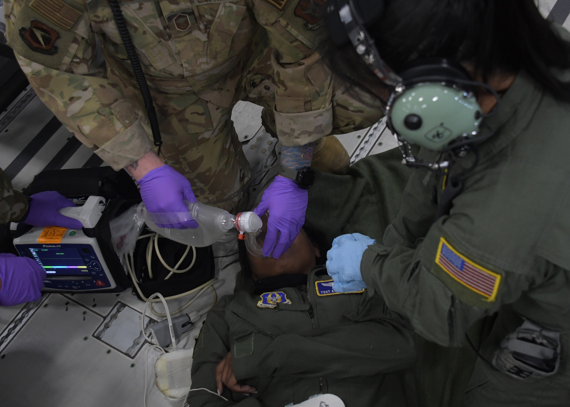 Aeromedical evacuation Airmen perform simulated CPR on a patient during an in-air medical emergency exercise aboard a new KC-46A Pegasus, April 23, 2021. The tanker, from the 916th Air Refueling Wing, was flown by the 77th Air Refueling Squadron, and was used by the aeromedical Airmen to become more familiar with the aircraft and its aeromedical evacuation capabilities. (U.S. Air Force photo by Tech. Sgt. Miles Wilson)