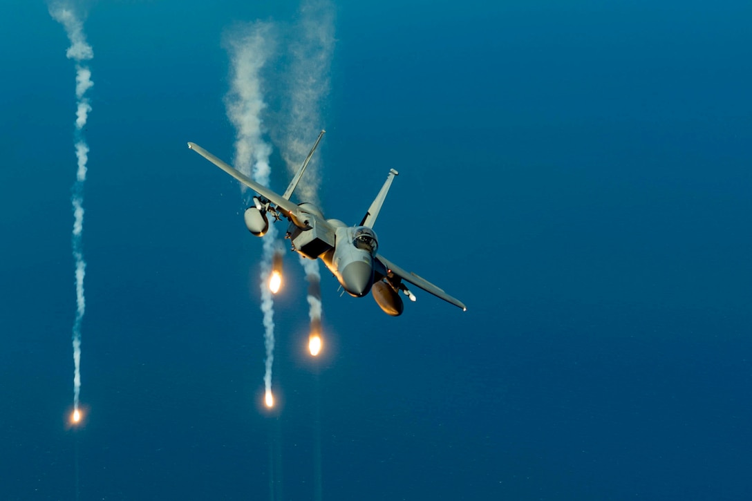 An aircraft flies as smoke streams are seen behind.