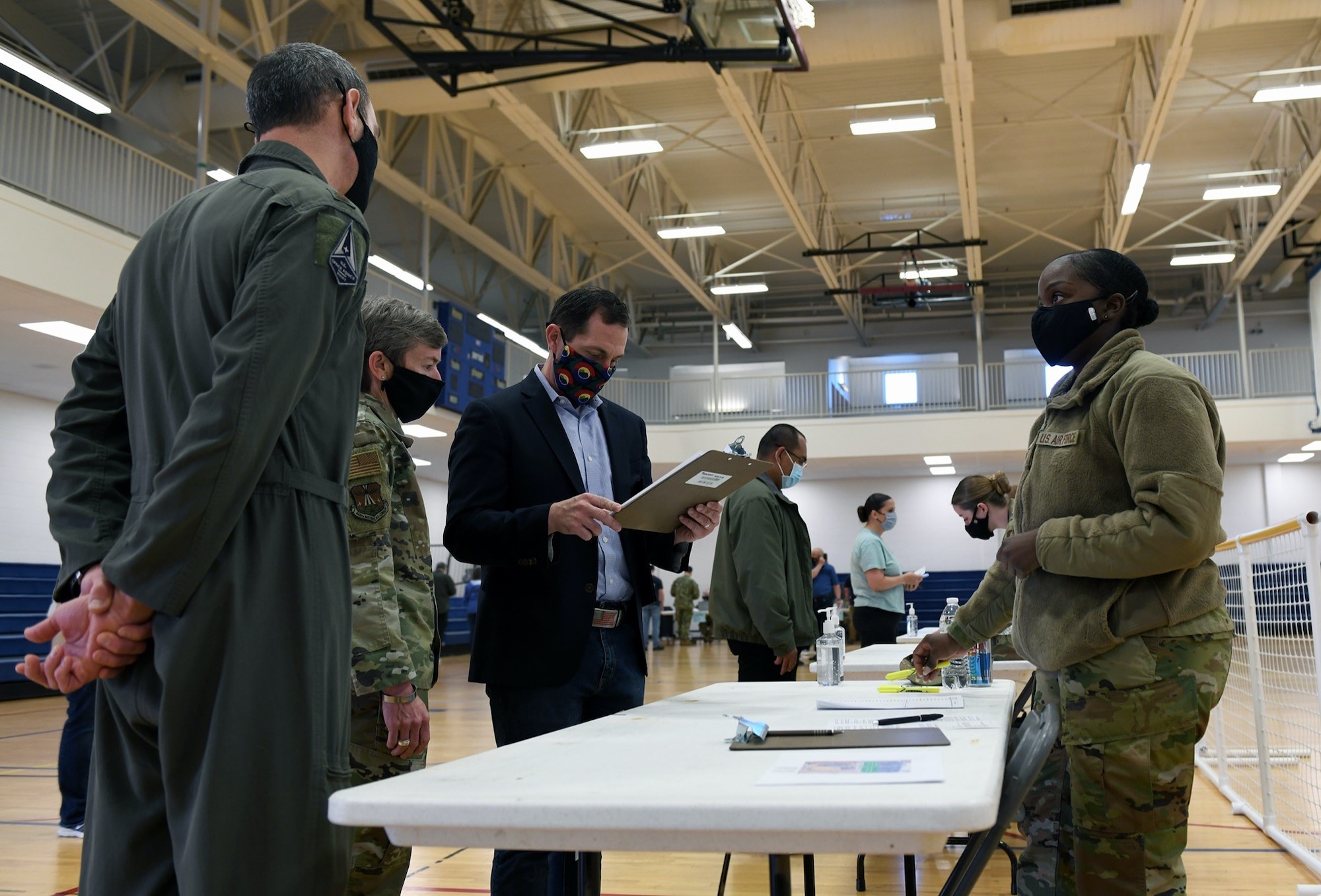 Staff Sgt. Simone Napue, far right, 566th Intelligence Squadron NCO in charge of operations support, explains to Congressman Jason Crow the first step of the vaccine distribution on Buckley Air Force, Colo., April 29, 2021. Crow visited Buckley to see first-hand how the 460th Medical Group operates the vaccine point of dispensing (POD). POD lines allow the Air Force to provide mass vaccinations to the beneficiaries or target population. (U.S. Space Force photo by Airman 1st Class Haley N. Blevins)