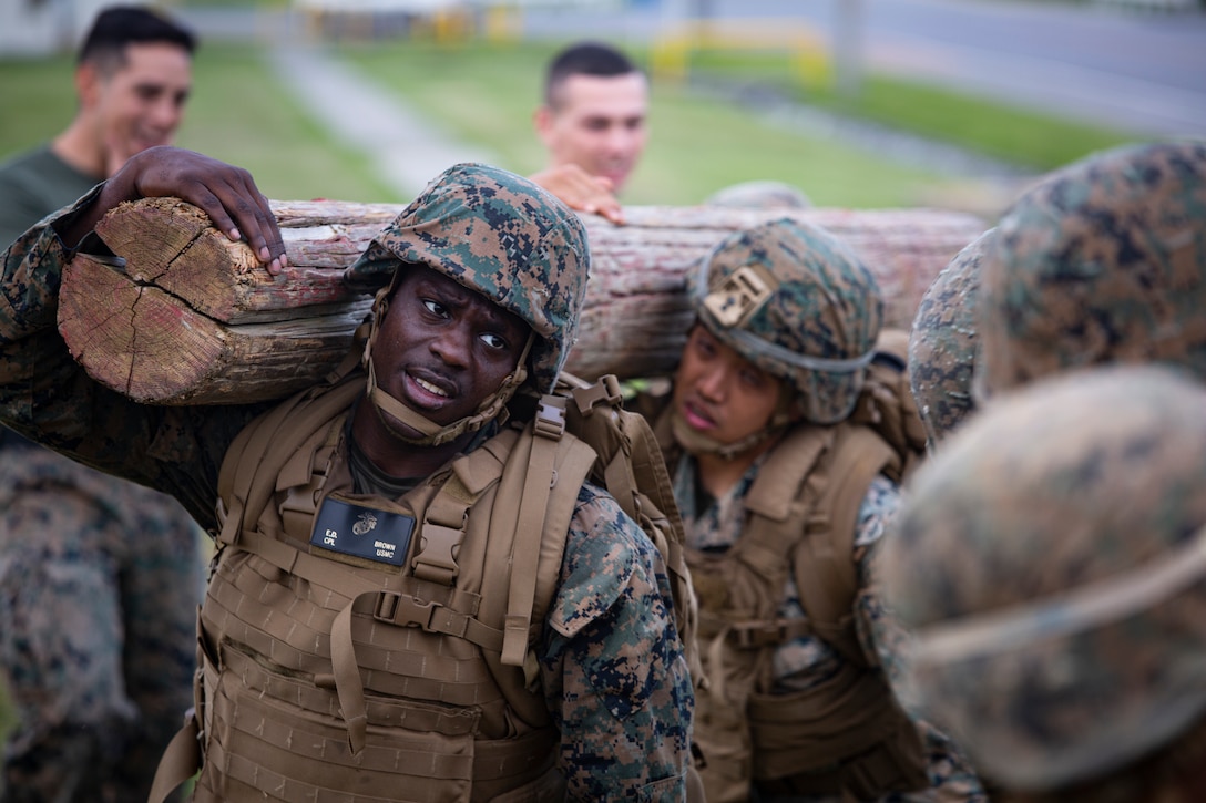 U.S. Marine Corps Cpl. Elbert Brown, air traffic controller, Headquarters and Headquarters Squadron, Marine Corps Air Station Futenma, carries a log during the culminating event of the Marine Corps Martial Arts Program (MCMAP) Instructor Course April 9, 2021on MCAS Futenma, Okinawa, Japan. The training was the first MCMAP instructor course hosted by H&HS in the past several years. The course awarded instructor tabs to Marines from several III Marine Expeditionary Force units and Headquarters and Headquarters Squadron. (U.S.Marine Corps Photo by Staff Sgt. Lucas Vega)