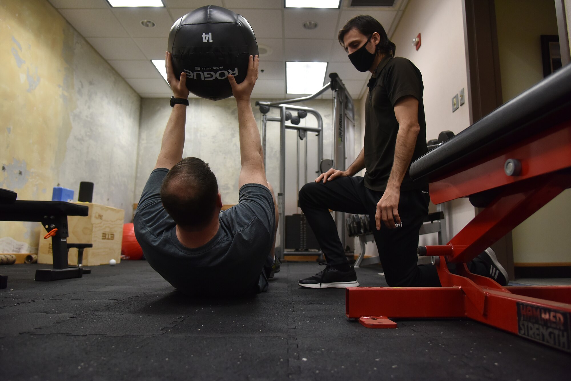 Lt. Col. Dustin “Chaos” Hudson, 8th Fighter Wing chief of safety, performs an abdominal exercise as Rodrigo Almada, 35th Fighter Squadron tactical athletic trainer, observes his form at Kunsan Air Base, Republic of Korea, April 5, 2021. Almada works on strengthening pilot’s necks and working on their core to make it easier for them to accomplish the flying mission. (U.S. Air Force photo by Senior Airman Suzie Plotnikov)