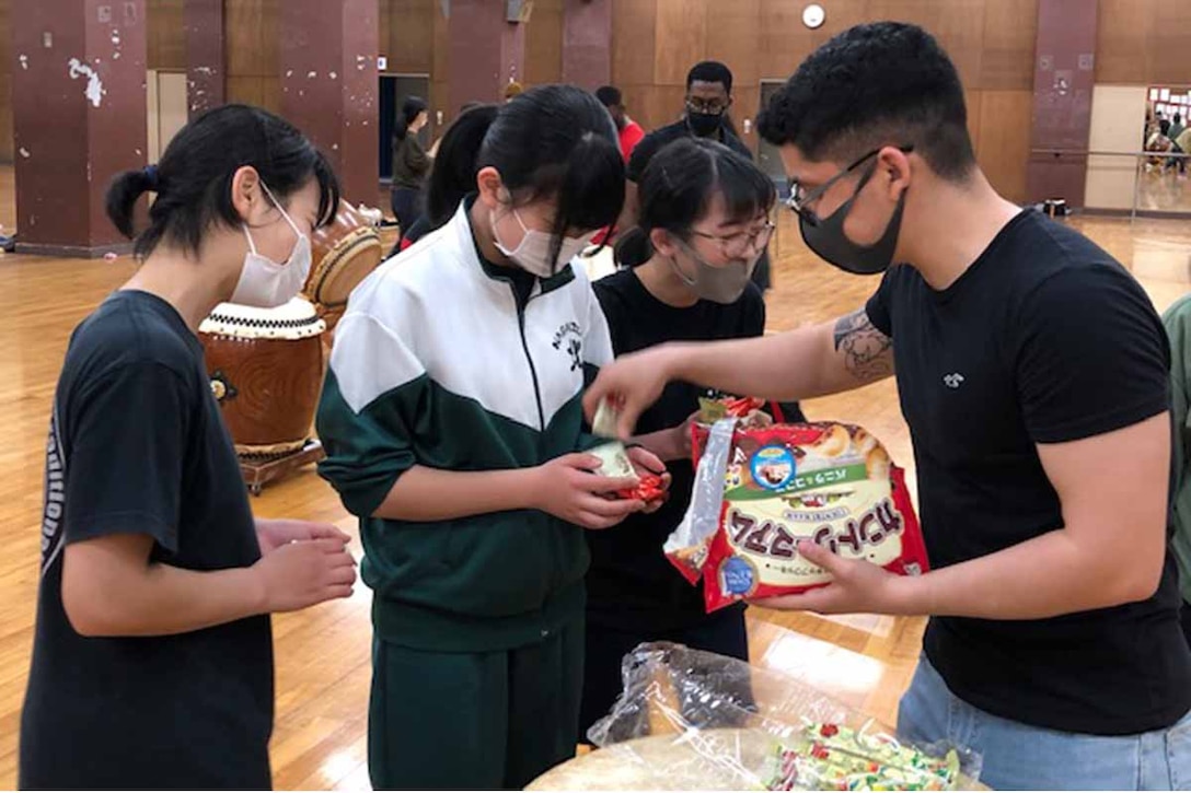 海兵隊員が持参したクッキーを地元中学生たちとシェアし、彼女たちの笑顔を誘う、２０２１年４月１７日、長泉北中学校体育館
