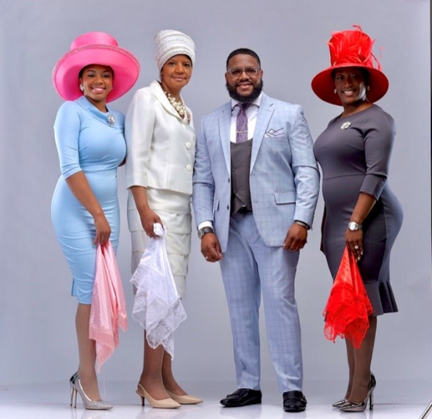 Alexander Harper stands next to models wearing some of his hat creations.