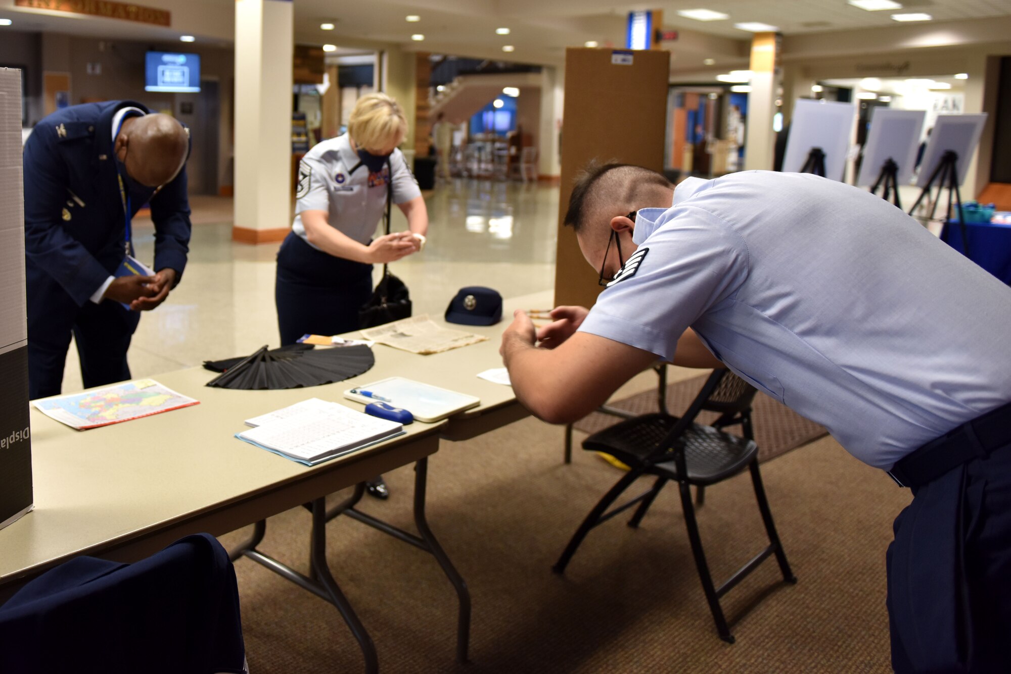 U.S. Staff Sgt. John Brazell, 316th Training Squadron global language mentor, teaches a proper Chinese middle bow to Col. James Finlayson, 17th Training Wing vice commander, and Chief Master Sgt. Casy Boomershine, 17th TRW command chief, at Angelo State University in San Angelo, Texas, April 29, 2021. During the Around the World International Cultural Fair, Goodfellow and ASU volunteers manned booths with various activities pertaining to a particular culture. (U.S. Air Force photo Staff Sgt. Seraiah Wolf)