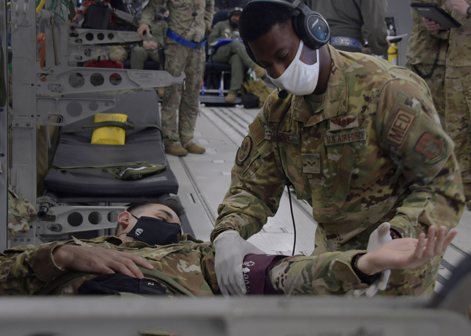 Airman Devon Martinez, a 94th Aeromedical Evacuation Squadron aeromedical evacuation technician, checks the blood pressure of a simulated patient during a training flight on a new KC-46A Pegasus from the 916th Air Refueling Wing, flown by the 77th Air Refueling Squadron, on April 23rd, 2021. During the flight, aeromedical evacuation Airmen from across the Air Force Reserve trained by participating in in-air medical emergencies. (U.S. Air Force photo by Tech. Sgt. Miles Wilson)