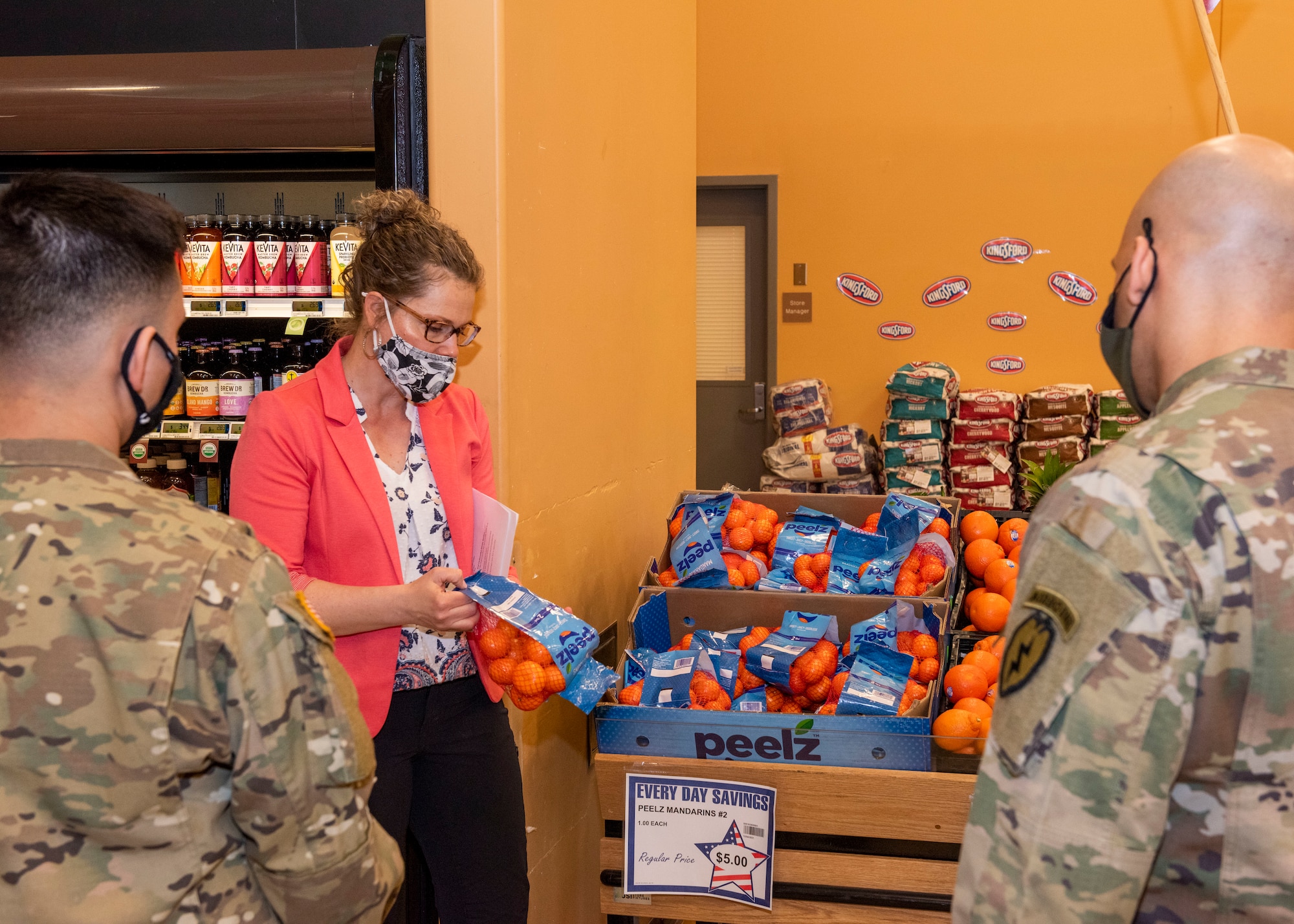 Marci McGill, the 673d Operational Medical Readiness Squadron Health Promotion dietician, talks about the nutritional values in fruit with U.S. Airmen and Soldiers during a Health Promotion-led Commissary tour at Joint Base Elmendorf-Richardson, Alaska, April 19, 2021. Health Promotion strives to promote health and wellness for all military members, their dependents, and Department of Defense civilians through community and group events to improve the health, mission readiness and productivity of the military community.