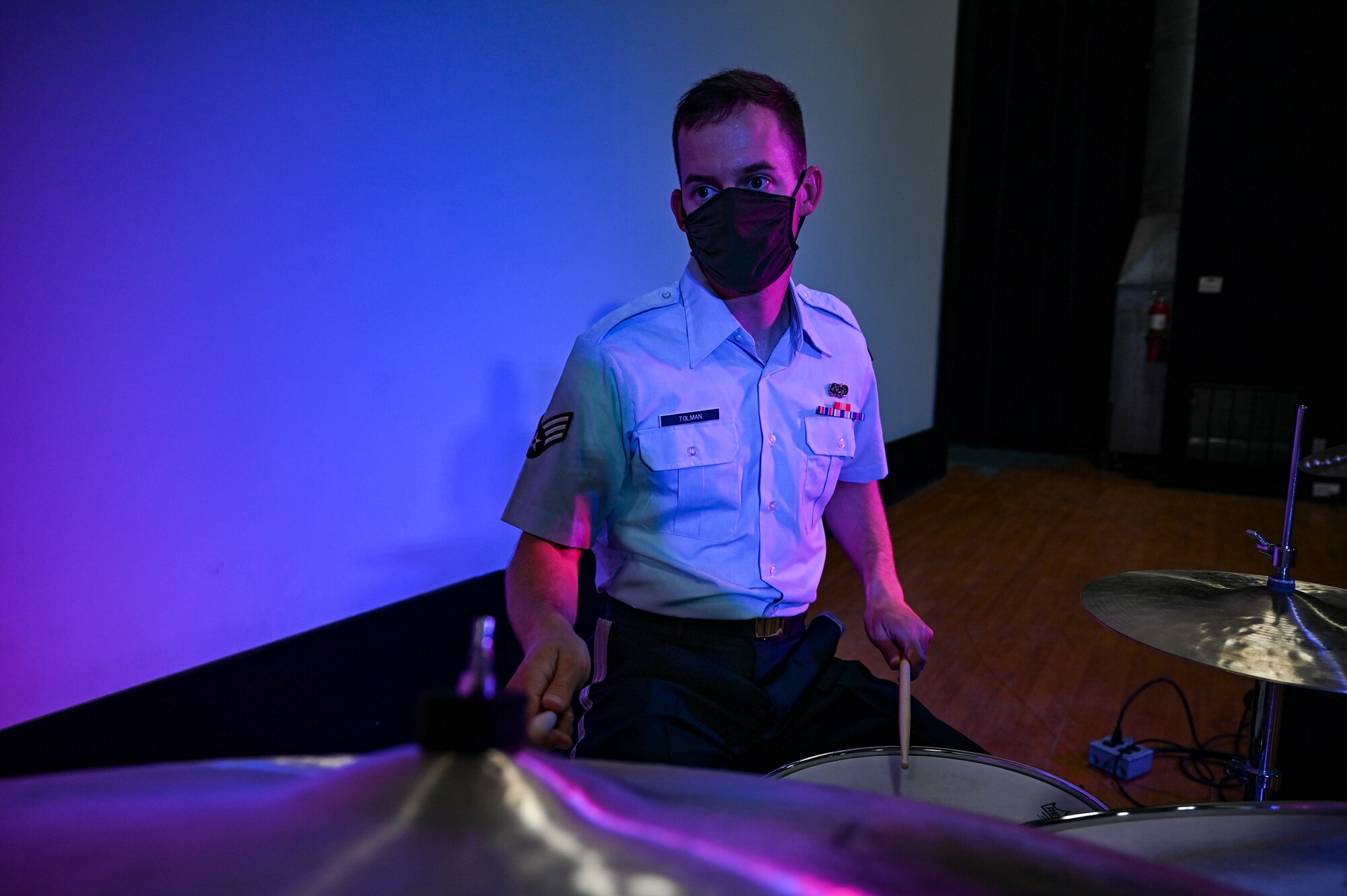 Senior Airman Brennan Tolman, a drummer assigned to the AFCENT Band, plays drums during an online concert for more than 50 students from the American International School located in Kuwait, April 25, 2021. The purpose of the concert was to introduce the students to American music, culture, and the AFCENT Band. (U.S. Air Force photo by Senior Airman Taylor Crul)