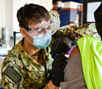 U.S. Navy Hospitalman Caleb Coker, a Jacksonville, Florida, native assigned to Navy Medicine Readiness and Training Command Camp Pendleton, California, administers the St. Louis Community Vaccination Center’s 20,000th COVID-19 vaccination, April 26, 2021.