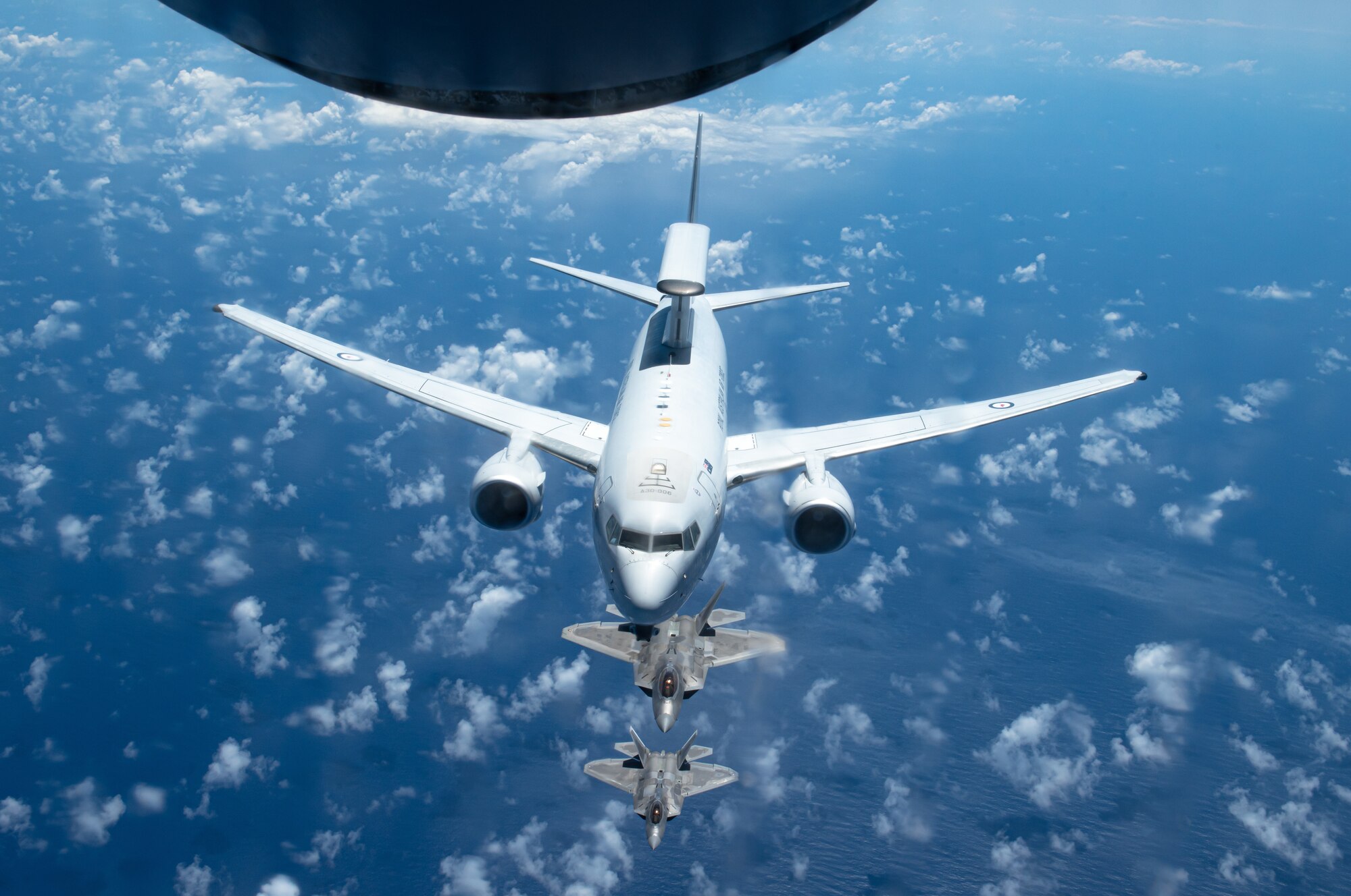 A Royal Australian Air Force E-7A Wedgetail, operated by No. 2 Squadron based at RAAF Base Williamtown, Australia, flies in formation with Hawaii Air National Guard F-22 Raptors April 21, 2021, near Oahu, Hawaii, as part of the Pacific Edge 21 exercise.