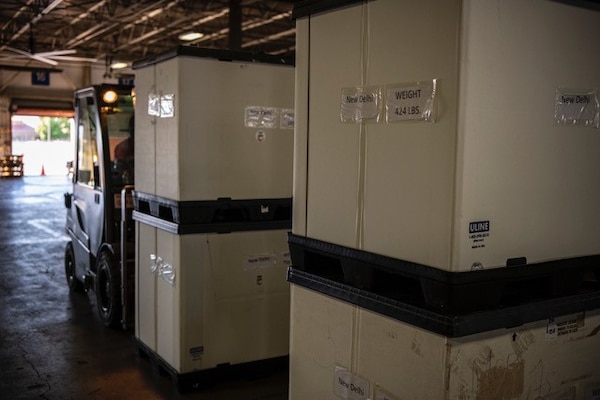 Pallets containing boxes of oxygen equipment are staged in a warehouse