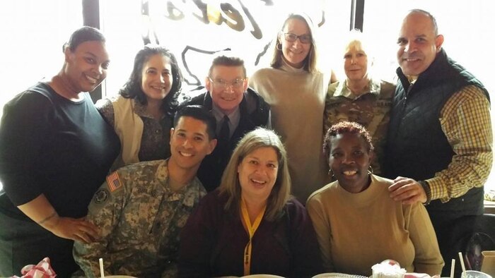 Ms. Vicki Mullen (seated at center), the Supervisory Transition Program Manager for the U.S. Marine Corps’ Wounded Warrior Regiment, poses for a photo alongside her then coworkers at the U.S. Army’s Recovery Care Program in Alexandria, Va., 2016. Mullen has dedicated 41 years of service towards assisting wounded, ill and injured service members.