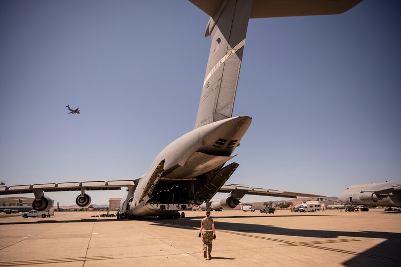 Airmen from the 22nd Airlift Squadron prepare a C-5M Super Galaxy to take lifesaving COVID-19 supplies to India, April 28, 2021, at Travis Air Force Base, Calif. The United States government, through the U.S. Agency for International Development, donated medical supplies to assist the country of India in its ongoing fight against COVID-19. The aid includes 440 oxygen cylinders and regulators, 1 million N95 masks and 1 million COVID-19 rapid diagnostic kits. (U.S. Air Force photo by Nicholas Pilch)