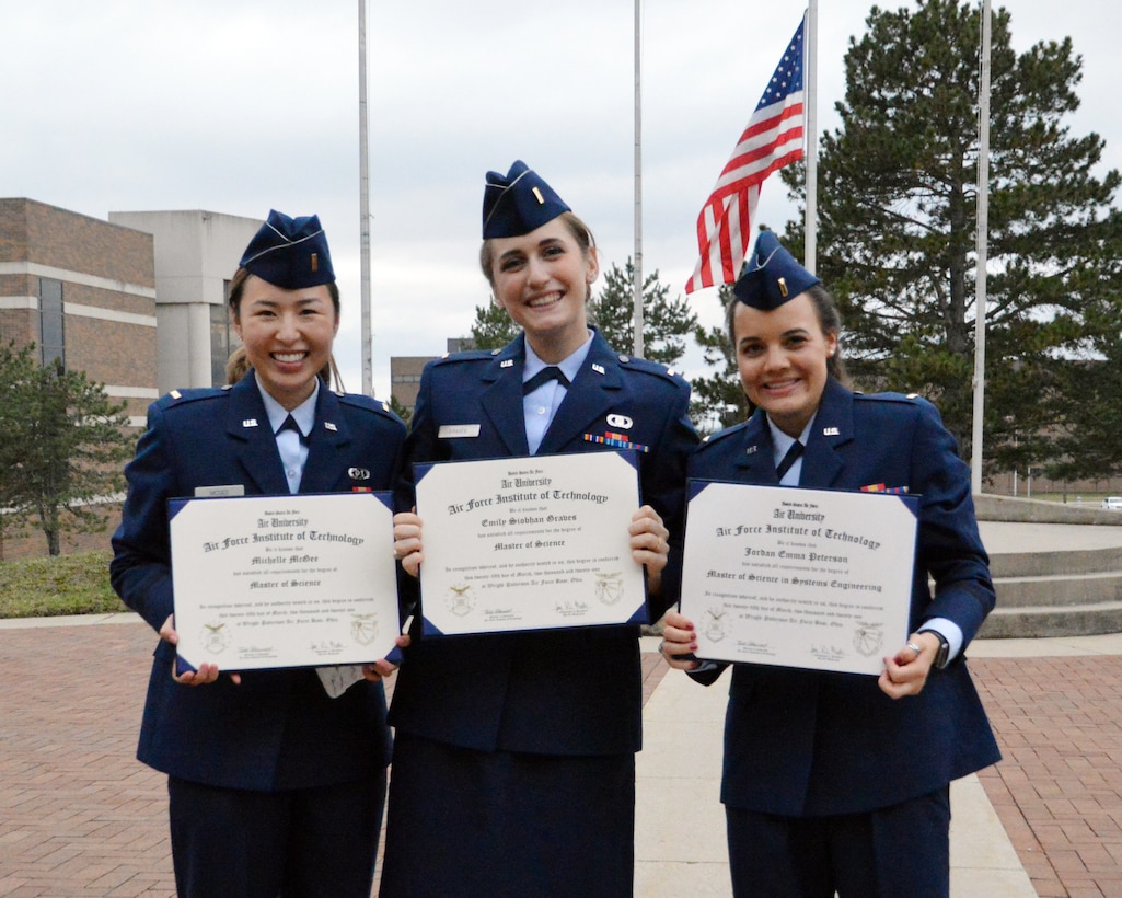Second Lts. Michelle McGee, Emily Graves and Jordan Peterson display their Master of Science diplomas following the March 25 commencement ceremony at the Air Force Institute of Technology.  The Higher Learning Commission reaffirmed AFIT's degree-granting post-secondary education accreditation for the maximum 10 year period in March.