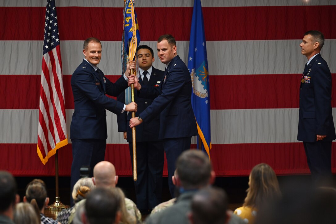 Col. Justin Spears, 14th Operations Group commander, hands Lt. Col. Paul Anderson, 50th Flying Training Squadron commander, the 50th FTS guidon at the 50th FTS change of command ceremony, April 30, 2021, on Columbus Air Force Base, Miss. The advanced phase of undergraduate pilot training is conducted by the 50th FTS where students fly the T-38C Talon trainer aircraft. (U.S. Air Force photo by Senior Airman Jake Jacobsen)
