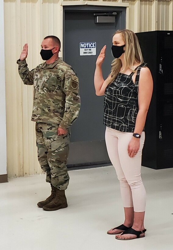 Reserve Citizen Airman Master Sgt. David Hart, 924th Maintenance Squadron Propulsion Flight superintendent, reenlists while his wife, Jennifer Hart, takes her first oath of enlistment in the U.S. Air Force Reserve at Davis-Monthan Air Force Base, Arizona, April 10, 2021. Airman Hart will begin basic training in June 2021 while Sergeant Hart stays behind to continuing serving in the unit and raising their six-year-old daughter.