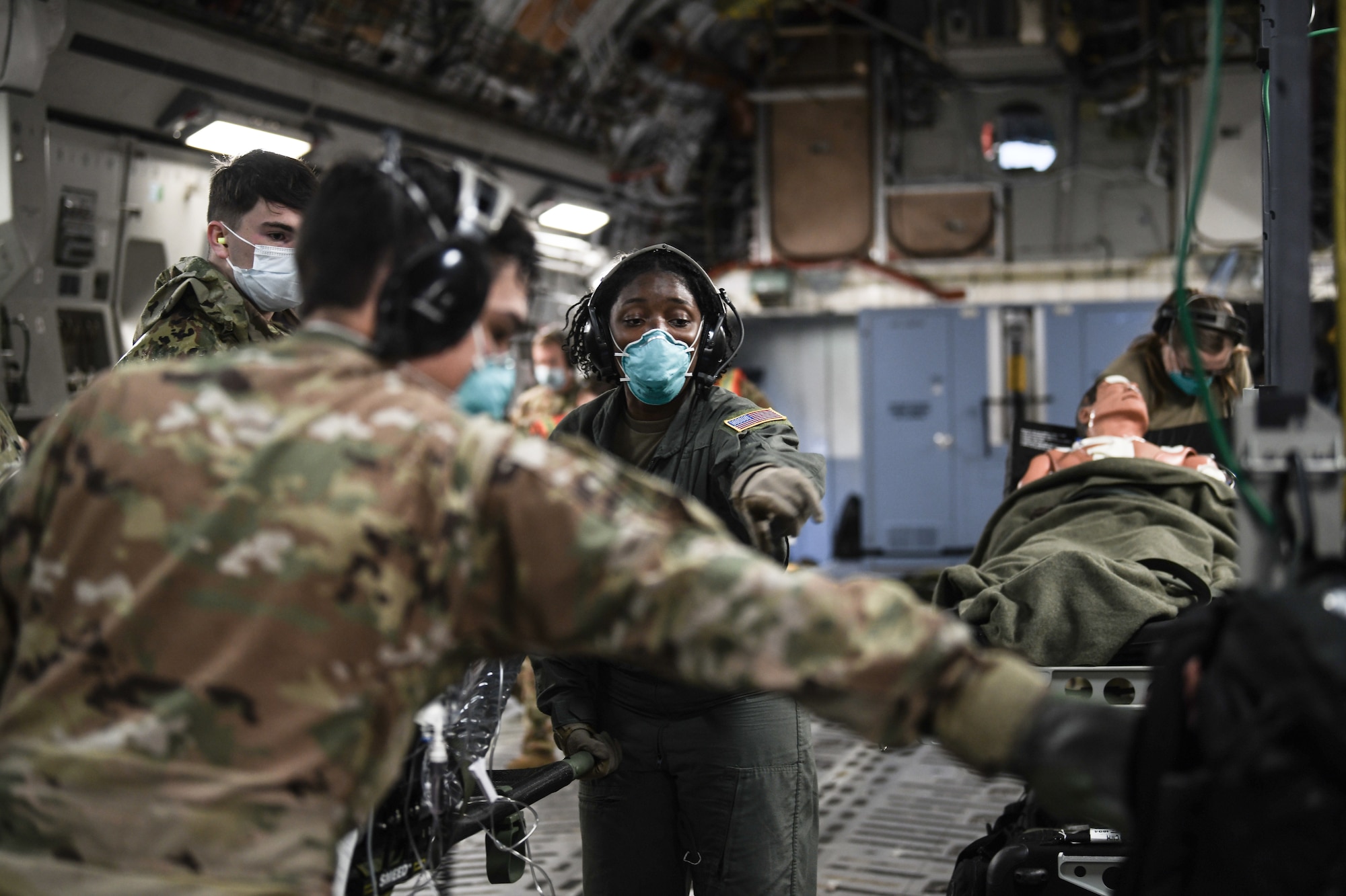 Senior Airman Shirneal Burnside, 445th Aeromedical Evacuation Squadron, gives direction to Airmen transporting patients onto a 445th Airlift Wing C-17 Globemaster III during the Ultimate Caduceus training exercise April 29, 2021. U.S. Transportation Command (USTRANSCOM) began a week-long aeromedical and global patient movement exercise, Ultimate Caduceus, April 26. Approximately 250 personnel including members of the 445th Airlift Wing and the 88th Air Base Wing participated in the field training exercise. (U.S. Air Force photo//Master Sgt. Patrick O’Reilly)