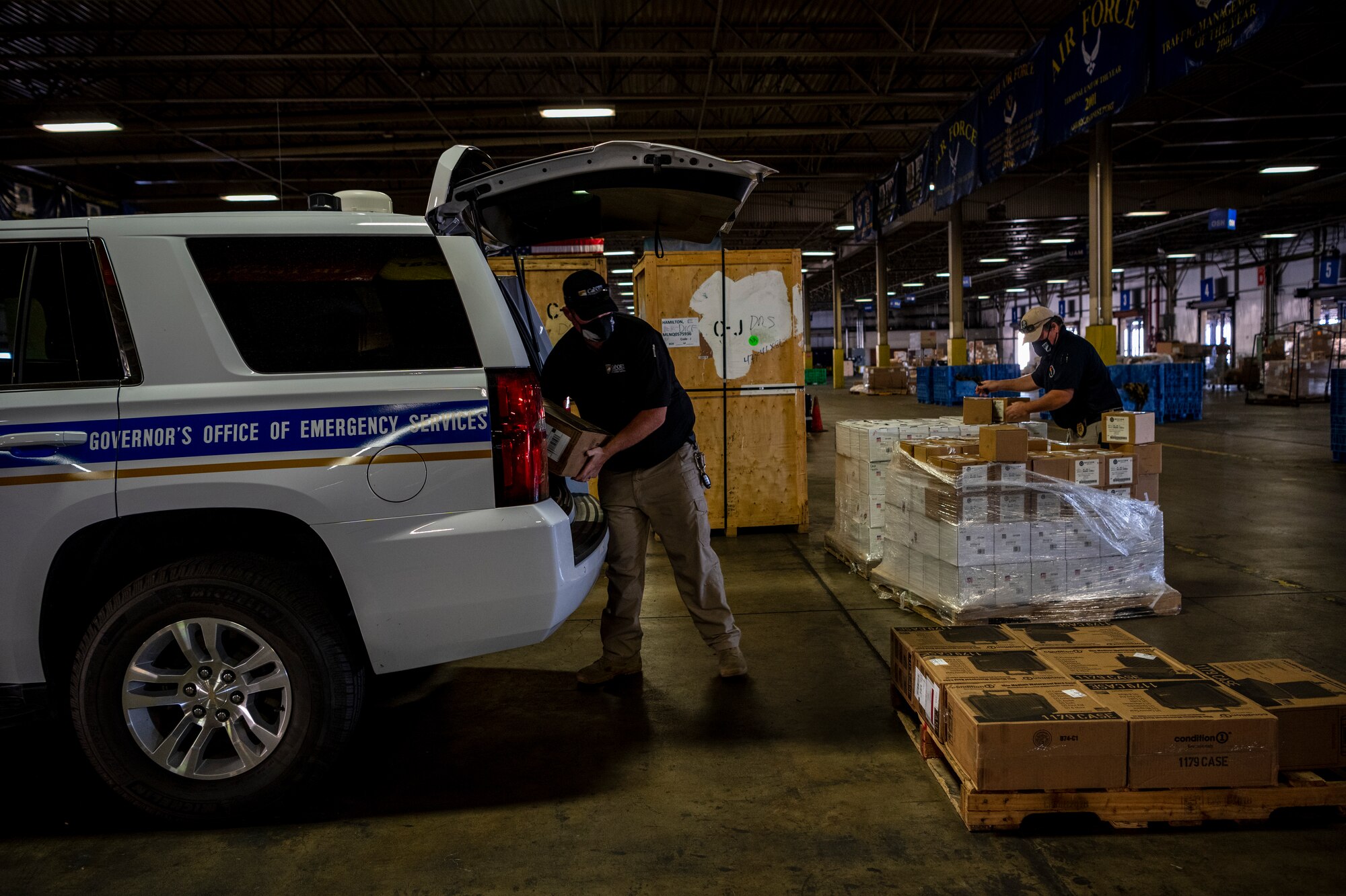 A man moves boxes from a truck to a pallet.