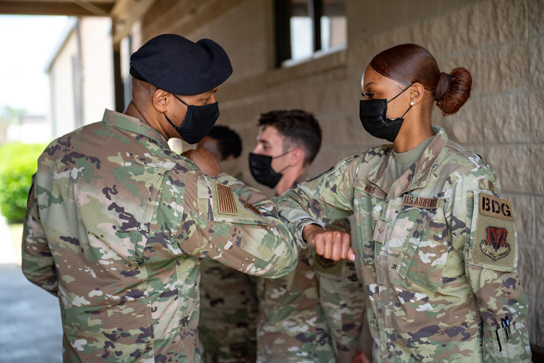 Photo of Airmen bumping elbows