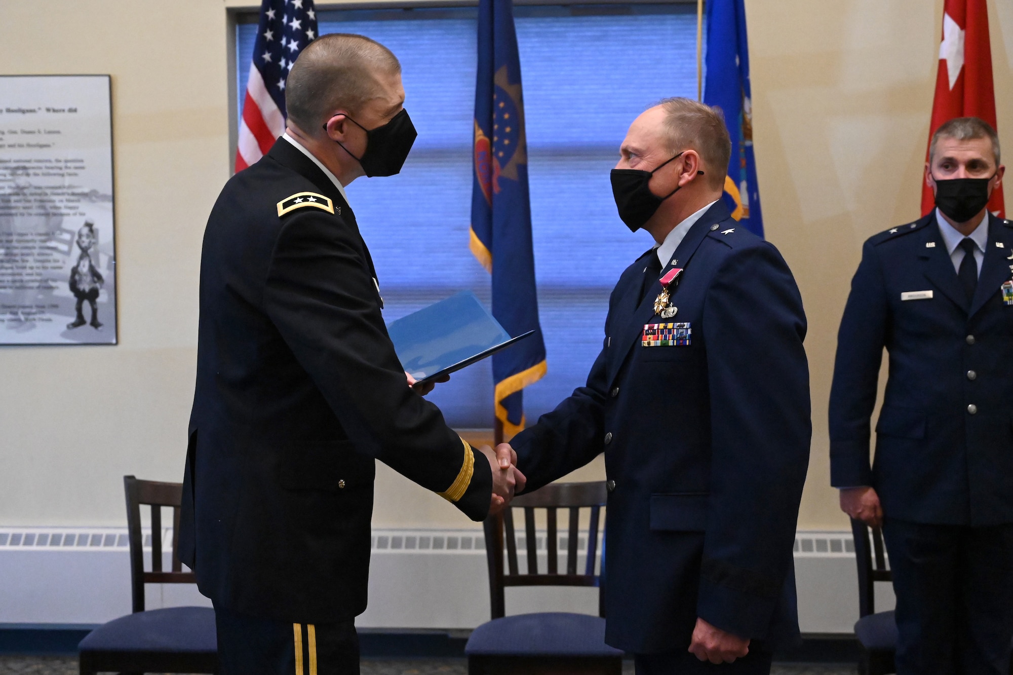 Maj. Gen. Al Dohrmann, the North Dakota adjutant general stands on the left of photo as he shakes hands with Brig. Gen. Todd Branden, the North Dakota assistant adjutant general for Air, during Branden's retirement ceremony at the North Dakota Air National Guard Base, Fargo, N.D., April 10, 2021.