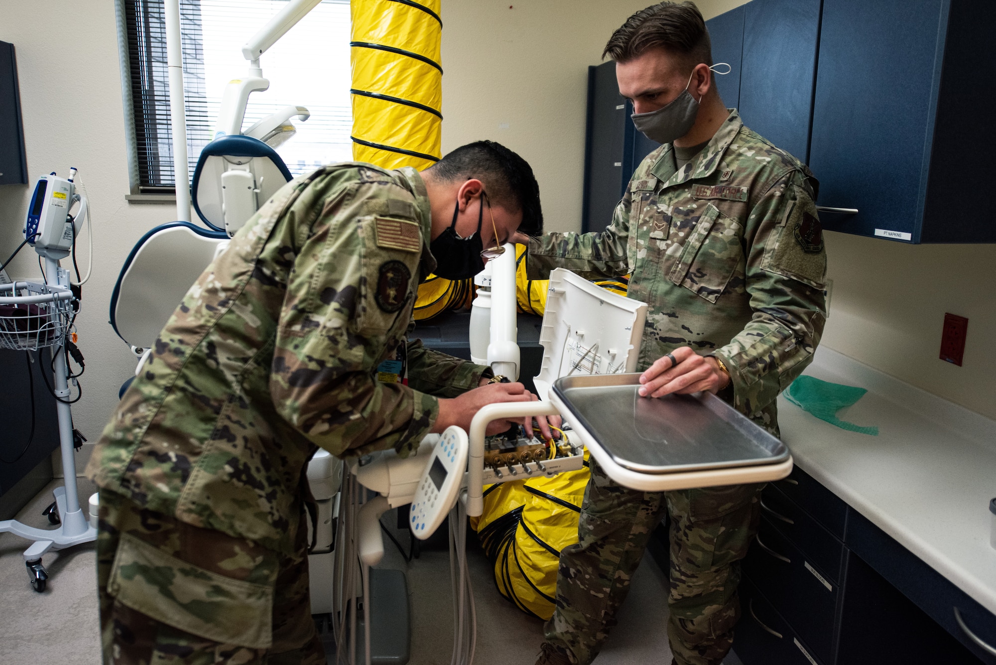 U.S. Air Force Airman 1st Class Eric Perez-Solano, 375th Medical Support Squadron biomedical equipment technician, and Airman 1st Class Sky Gauvin, 137th Aeromedical Evacuation Squadron biomedical equipment technician, repair a dental chair at Scott Air Force Base, Illinois, April 23, 2021. Biomedical equipment technicians repair medical equipment and inspect to ensure the equipment is operating correctly. (U.S. Air Force photo by Airman 1st Class Isaac Olivera)