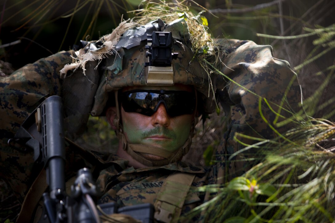 U.S. Marine Corps Cpl. Tyler Pearson, squad leader, Fox Company, 2nd Battalion, 8th Marine Regiment, takes a break from the sun and listens to the instructions for the steep incline repel event during the Advanced Infantry Course at Kahuku Training Area, Hawaii, April 22, 2021. This course is an experimental proof of concept with the intent of modernizing training and providing squad leaders with new capabilities. (U.S. Marine Corps photo by Lance Cpl. Terry Stennett III)