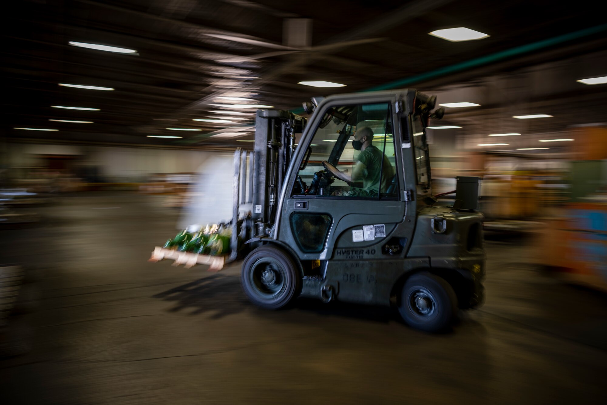 A forklift is seen driving through a large warehouse.