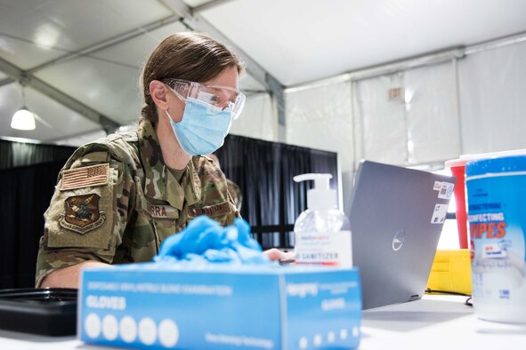U.S. Air Force Maj. Helena Guerra, 22nd Medical Group bravo flight commander, prepares her station for her next COVID-19 vaccine patient April 28, 2021, at the Community Vaccination Center (CVC) in St. Paul, Minnesota. The total-force team consists of approximately 140 Airmen from 24 installations across the country. (U.S. Air Force photo by Senior Airman Alexi Bosarge)