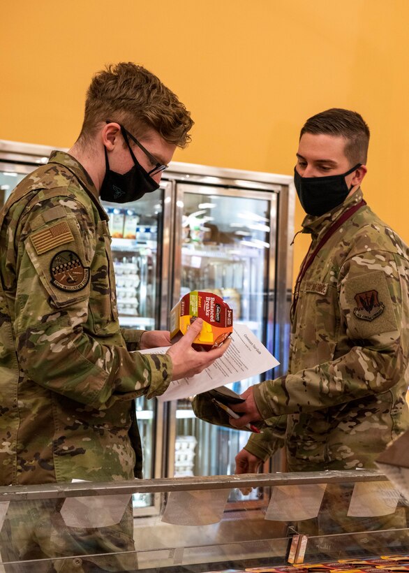 U.S. Air Force Senior Airman Zachary Alexander, left, a signals intelligence analyst assigned to the 301st Intelligence Squadron, and U.S. Air Force Senior Airman David Gothay, a Russian linguist assigned to the 381st Intelligence Squadron, look at a nutrition label during a Health Promotion-led Commissary tour at Joint Base Elmendorf-Richardson, Alaska, April 19, 2021. Health Promotion strives to promote health and wellness for all military members, their dependents, and Department of Defense civilians through community and group events to improve the health, mission readiness and productivity of the military community.
