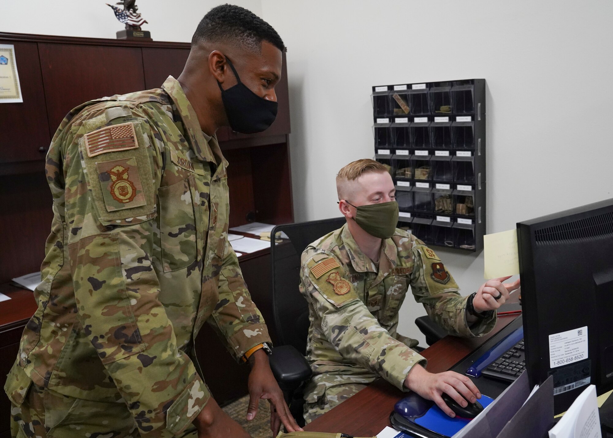 U.S. Air Force Senior Master Sgt. Travis Jordan, 81st Security Forces Squadron operation superintendent, helps Staff Sgt. Blake Johnson, 81st SFS unit scheduler inside the security forces building at Keesler Air Forces Base, Mississippi, April 29, 2021. Jordan serves as a mentor for the Airmen in his unit. (U.S. Air Force photo by Senior Airman Spencer Tobler)