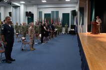 210729-N- IG466-0140 NAVAL SUPPORT ACTIVITY BAHRAIN (July 29, 2021) – Capt. Christopher Gilbertson, right, outgoing commander of Destroyer Squadron (DESRON) 50 and Task Force (TF), reads his orders during a change of command ceremony presided over by Vice Adm. Brad Cooper, commander, U.S. Naval Forces Central Command, U.S. 5th Fleet and Combined Maritime Forces, onboard Naval Support Activity Bahrain, July 29. DESRON 50 and TF 55 operate in the U.S. 5th Fleet area of operations in support of naval operations to ensure maritime stability and security in the Central Region, connecting the Mediterranean and Pacific through the western Indian Ocean and three critical chokepoints to the free flow of global commerce. (U.S. Navy photo by Mass Communication Specialist 2nd Class Adelola Tinubu)