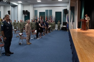 210729-N- IG466-0140 NAVAL SUPPORT ACTIVITY BAHRAIN (July 29, 2021) – Capt. Christopher Gilbertson, right, outgoing commander of Destroyer Squadron (DESRON) 50 and Task Force (TF), reads his orders during a change of command ceremony presided over by Vice Adm. Brad Cooper, commander, U.S. Naval Forces Central Command, U.S. 5th Fleet and Combined Maritime Forces, onboard Naval Support Activity Bahrain, July 29. DESRON 50 and TF 55 operate in the U.S. 5th Fleet area of operations in support of naval operations to ensure maritime stability and security in the Central Region, connecting the Mediterranean and Pacific through the western Indian Ocean and three critical chokepoints to the free flow of global commerce. (U.S. Navy photo by Mass Communication Specialist 2nd Class Adelola Tinubu)